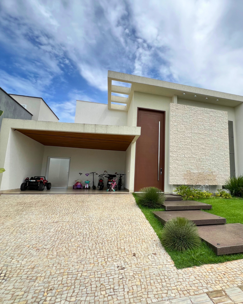 Entrada da casa com porta pivotante feita pela Alumiter